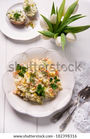 potato salad with boiled vegetables, sweet corn, peas and herbs