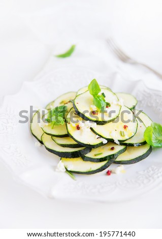 zucchini salad with mozzarella cheese, basil leaves and olive oil