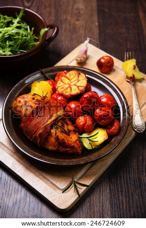 chicken breast wrapped in parma ham with cherry tomatoes, garlic and herbs