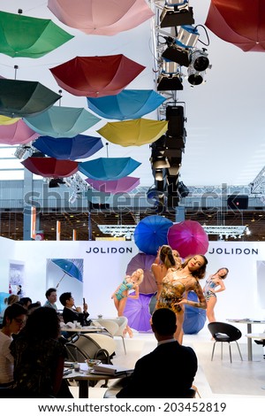 PARIS, FRANCE - JULY 5, 2014: Models dance in a booth at Mode City, a swimwear and lingerie tradeshow where over 20,000 buyers meet 500 exhibitors from 35 different countries.