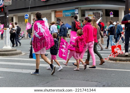 PARIS, FRANCE - OCT. 5, 2014: A family dressed with pink flags march during an anti-gay rights protest in Paris. The manifestation drew around 100,000 people that day.