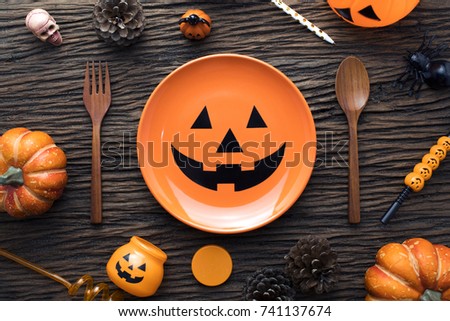 orange dish and decorations of halloween dinner party on wooden