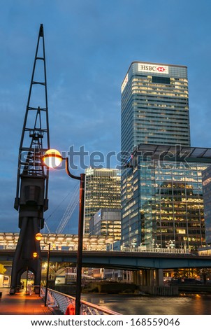 LONDON - MAY 9: HSBC\'s World Head Quarters building and old port cranes at Canary Wharf at night on May 9, 2011 in London. It is part of the redevelopment around Canary Wharf in the London Docklands.