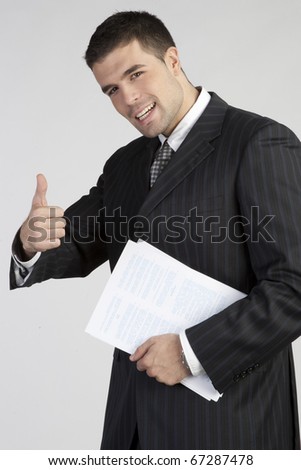 Young businessman showing thumb up. Sign \