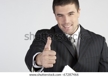 Young businessman showing thumb up. Sign \