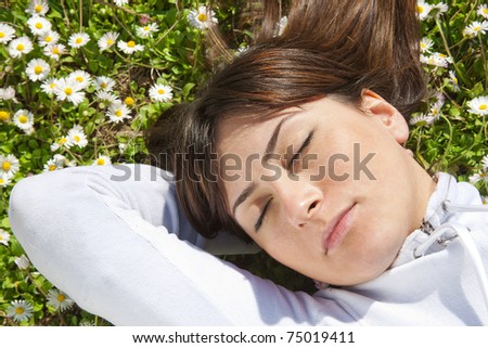 young woman lying in grass dreaming summer day
