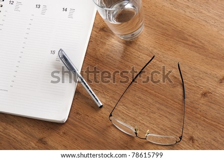 library desk with books, glasses and pen