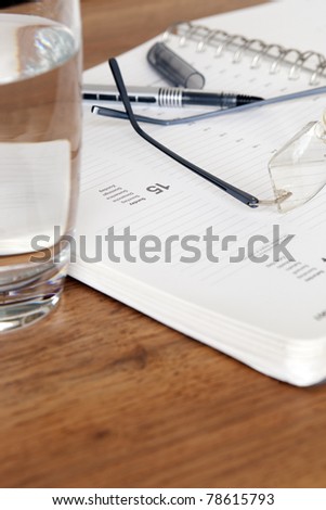 library desk with books, glasses and pen