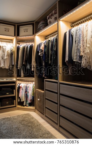 Luxurious walk in closet with lighting and jewelry display.