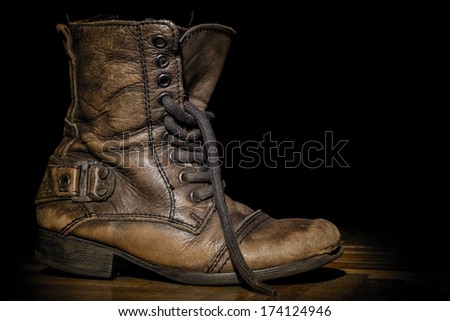 Old boot on the dark background.