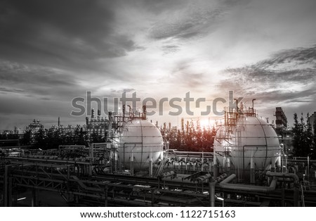 Gas storage sphere tanks and pipeline in oil and gas refinery industrial plant on sky sunset background
