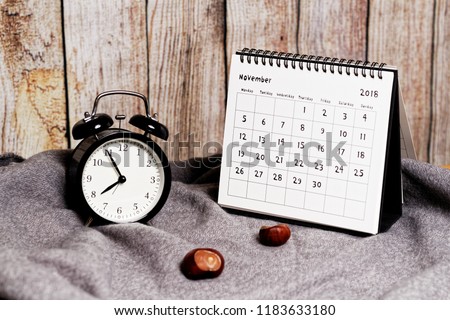 Five to eight on vintage clock, chestnuts and November 2018 calendar. Autumn time and mood