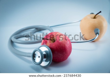 Stethoscope and red apple on white background