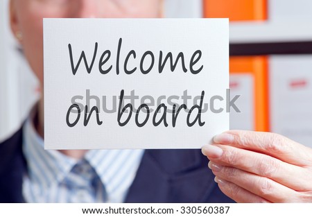 Welcome on board - Businesswoman holding white sign with text in the office