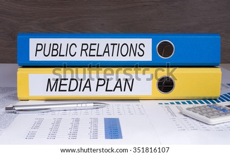 Public Relations and Media Plan - blue and yellow binder on desk in the office