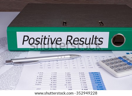 Positive Results binder with green color on desk in the office