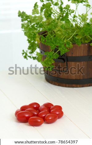 cherry tomatoes on the table, parsley in background, focus on tomatoes
