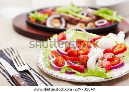 baked diced chicken and sausage with onions, peppers, mushrooms and a salad of tomatoes, mushrooms, peppers and lettuce.