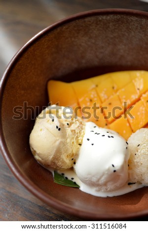 Selective focus of mango ice cream and vanilla ice cream with mango flesh and sticky rice