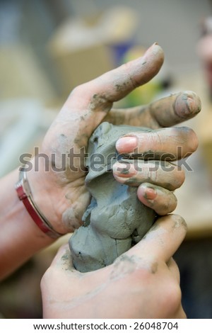 Picture of squeezing clay hands.