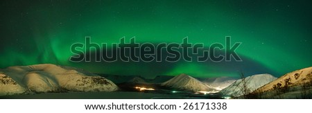 Panorama of arc of Aurora polaris above mountains