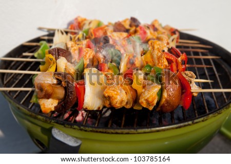 Bar-B-Q or BBQ with kebab cooking. coal grill of chicken meat skewers with mushroom and peppers. barbecuing dinner