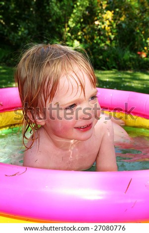 paddling pool in garden with small boy. summer holiday or vacation relaxing