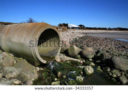 waste pipe or drainage polluting environment. concrete pipes by beach