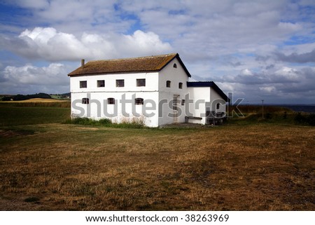 farm house isolated in a field in the countryside . a lonely building in a meadow in denmark