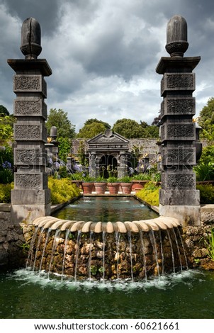 garden park with wooden architecture and water and fountain. ornamental flower garden