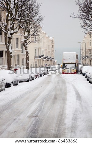 street in winter with abandoned bus and snow covered cars. English road in Brighton  with regency houses, apartments or flats