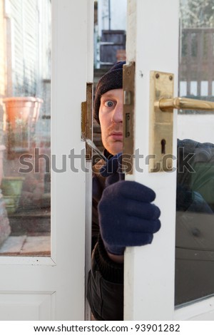 Breaking and entering home or house, Burglar with screwdriver force open door. Thief attempting to breach security