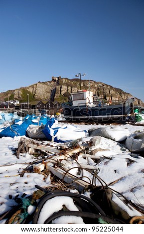fishing industry, trawler or fishing boat on the beach in seaside resort of Hastings in England. South UK shoreline in winter snow
