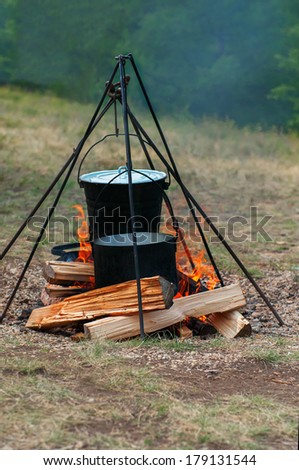 Hiking bucket and pan over the fire with woods
