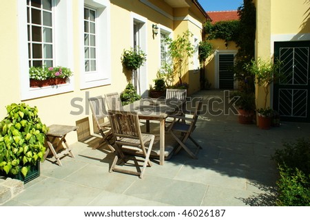 Patio with table and cane chair in a backyard