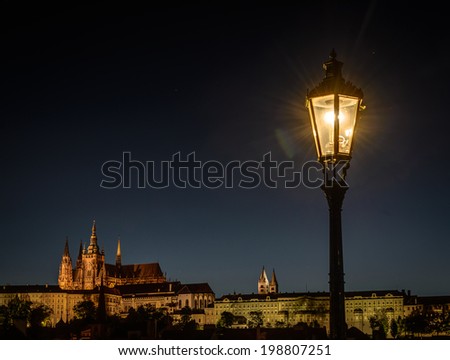Night view of lantern on a Charles Bridge and Prague Castle in background,Czech Republic .