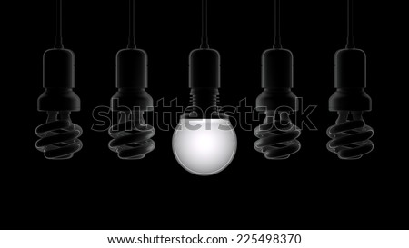 Glowing light bulb illuminating other ones on black background