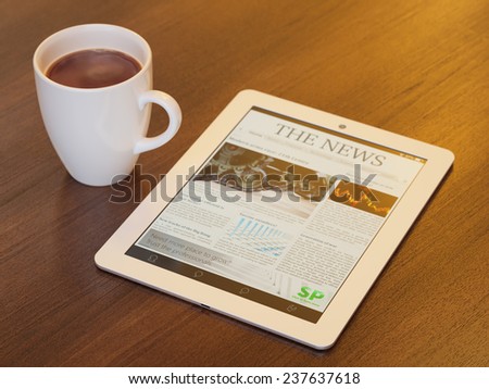 Tablet PC with launched news site or application on it and cup of coffee