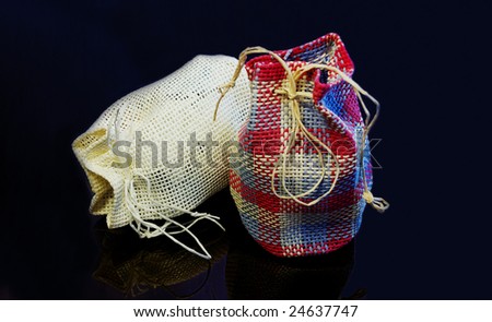 Pair of traditional country styled gift bags on black glassy background. Low key lighting.