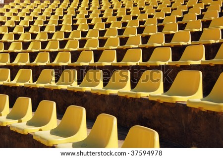 Rows of empty yellow seats in a open-air theater (amphitheater)