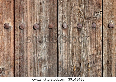 Weathered wooden fence texture with rusty forged nail heads