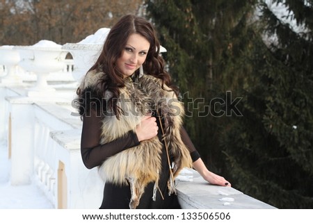 Young woman in fur jacket in park
