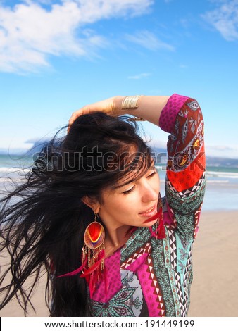 Portrait of young beautiful woman looking into the distance on the Sunrise beach in Cape Town. South Africa. Blowing long hair. Fashion shooting. Oriental style. Boho-chic.