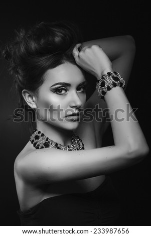 Portrait of young beautiful  woman with fashion hairstyle . Fashion model shooting. Gold  jewelry with precious stones.