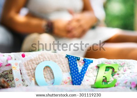 Engagement couple on picnic with letters love in front