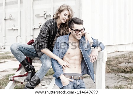 stylish couple wearing jeans and boots smiling - retro processed image
