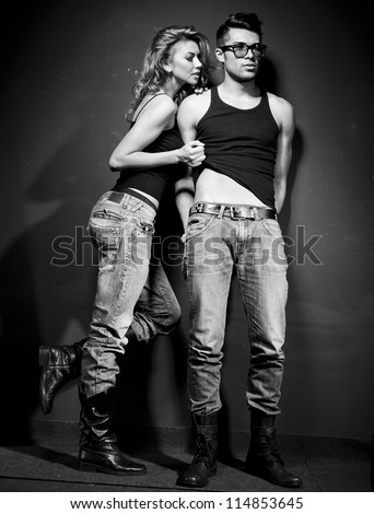 Sexy man and woman doing a fashion photo shoot in a professional studio