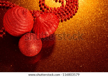 red glitter Christmas baubles on golden glitter background - copy space