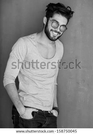 Sexy Fashion Man With Beard Dressed Casual Smiling Against Wall