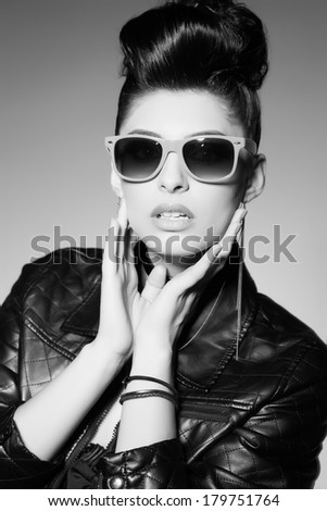 beautiful punk woman model wearing sun glasses and leather jacket
